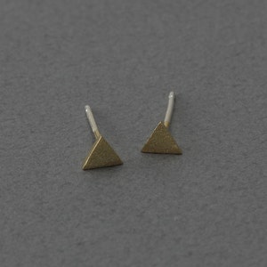 Puede incluir: Un par de pendientes de botón triangulares de oro con acabado cepillado.