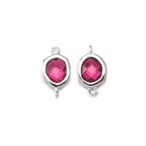 May include: Two silver-toned metal clasps with a pink faceted gemstone in the centre. The clasps are designed to be used for jewellery making.