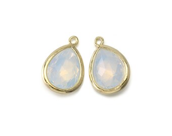 May include: Two gold teardrop-shaped pendants with clear iridescent glass stones.