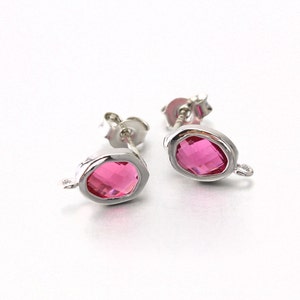 Puede incluir: Un par de pendientes de plata con piedras preciosas facetadas de color rosa. Los pendientes tienen un diseño sencillo y son perfectos para el uso diario.