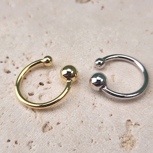 May include: Two hoop earrings with ball ends. One earring is gold and the other is silver.