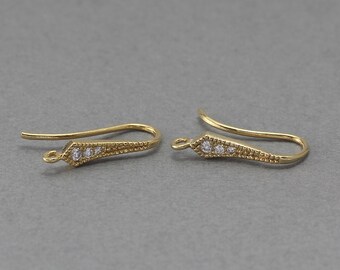 May include: Two gold-toned earring hooks with a textured design and clear rhinestones.