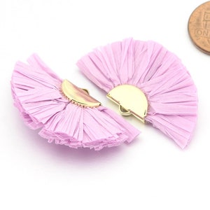 May include: Two lavender fabric fan-shaped earrings with gold metal accents. The earrings are approximately 5 cm in diameter.