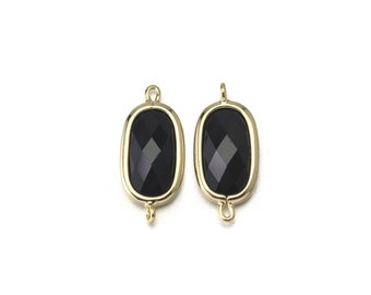 May include: Two gold-toned oval-shaped connectors with black faceted glass inserts. The connectors have a loop on each end.
