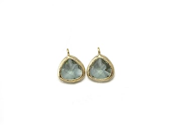 May include: Two gold-toned pendants with a teardrop-shaped green glass stone.