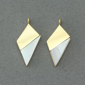 May include: Two gold and white geometric pendant charms with a diamond shape. The charms are made of metal and have a white mother of pearl inlay.