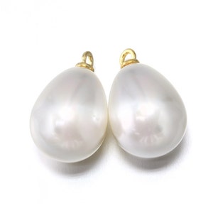 May include: Two white pearlescent teardrop-shaped pendants with gold jump rings.