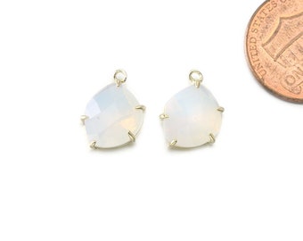 May include: Two white opal gemstone pendants with gold settings. The opals are faceted and have a pear shape.