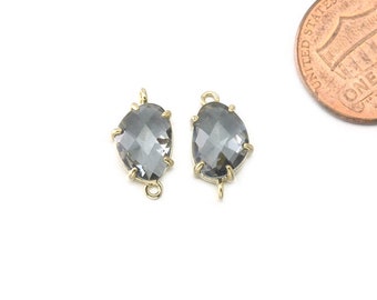 May include: Two gold-tone pendant charms with a teardrop-shaped clear gray crystal.
