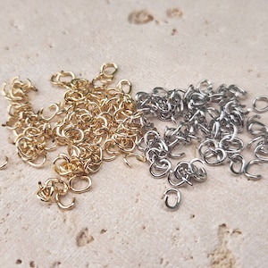 May include: A pile of gold and silver jump rings. The jump rings are small and are perfect for jewellery making.