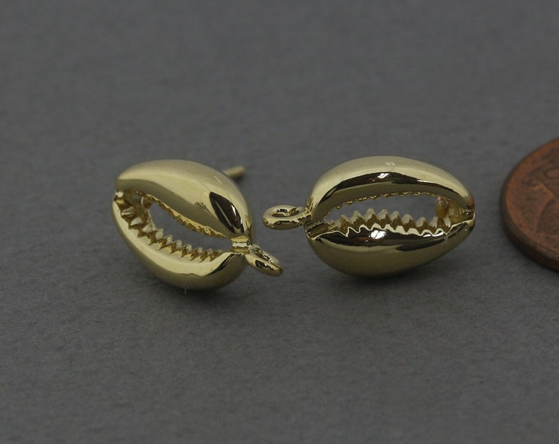 May include: A pair of gold-tone shell-shaped earrings. The earrings are small and have a detailed design.