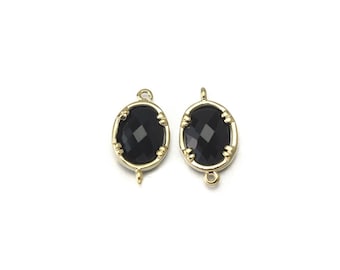 May include: Two gold-toned oval-shaped pendant charms with black faceted glass stones. Each charm has a loop at the top for attaching to a necklace or bracelet.