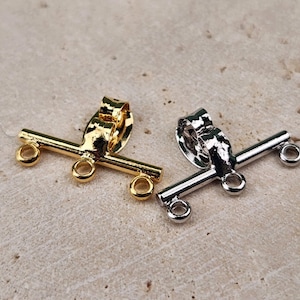 May include: Two toggle clasps, one gold and one silver, for jewelry making. Each clasp has a bar with two loops on each end.