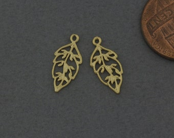 May include: Two gold-colored metal leaf-shaped charms with intricate cut-out designs. The charms have a loop at the top for attaching to jewelry or other crafts.