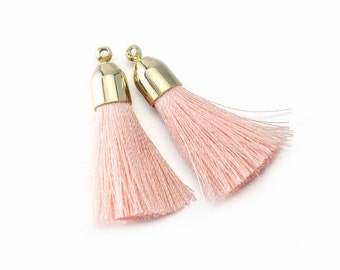 May include: Two pink tassel trim with gold metal caps.