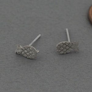 Op de afbeelding: Een paar zilveren ananas oorbel studs. De oorbellen zijn klein en delicaat, en ze hebben een gedetailleerd ananas ontwerp.