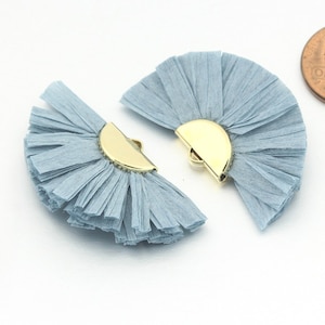May include: Two light blue paper fan embellishments with gold metal half-circle clasps. The embellishments are approximately the size of a UK penny.