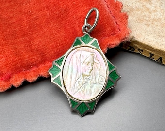 Peut inclure: Un pendentif en argent avec une bordure en émail vert et un camée blanc représentant le visage d'une femme. Le pendentif est en forme d'étoile.