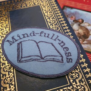 May include: A blue embroidered patch with the text "Mindfulness" and an open book design.