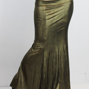 May include: A long, flowing skirt with a mermaid-style hem. The skirt is made of a shimmery, metallic fabric in a gold colour.