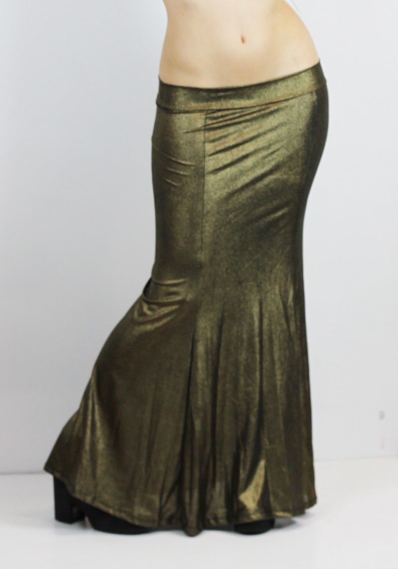 May include: A long, flowing skirt with a mermaid-style hem. The skirt is made of a shimmery, metallic fabric in a gold colour.