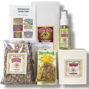 May include: A Protection From Envy kit containing a clear plastic bag of dried herbs, a small yellow organza pouch with a metal charm, a white box of soap, a spray bottle of perfume, and an instruction sheet, all featuring the all-seeing eye symbol.