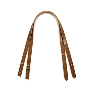 May include: A brown leather shoulder strap with metal rivets. The strap is made of two pieces of leather that are sewn together.