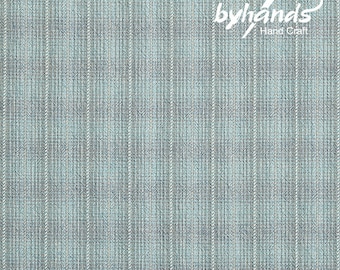 May include: A close-up of a textured fabric with a vertical striped pattern in shades of gray and light blue. The fabric has a woven appearance. The words "byhands Hand Craft" are in white script in the upper right corner.