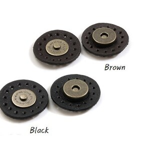 May include: Two sets of leather magnetic closures, one set in black and one set in brown. Each set includes two round pieces with a metal button in the center.