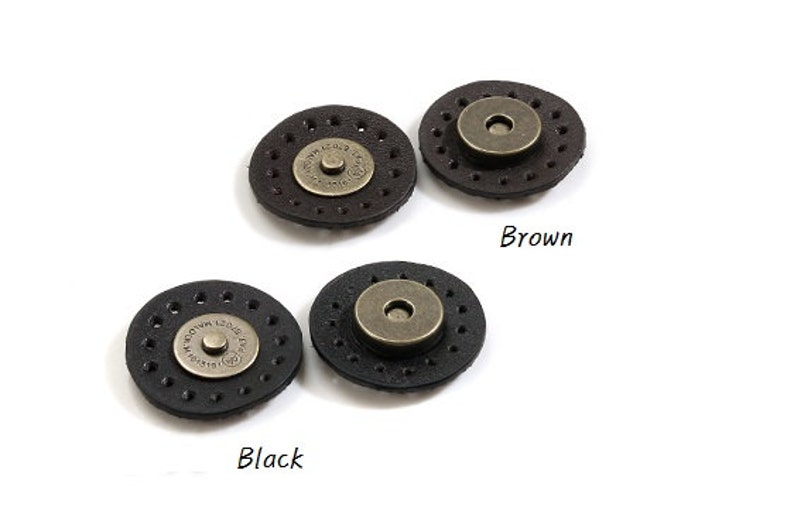 May include: Two sets of leather magnetic closures, one set in black and one set in brown. Each set includes two round pieces with a metal button in the center.