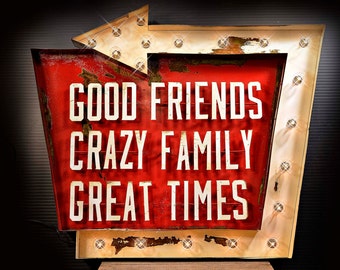 May include: A vintage-style metal sign with a red background and white lettering. The sign reads "Good Friends Crazy Family Great Times".