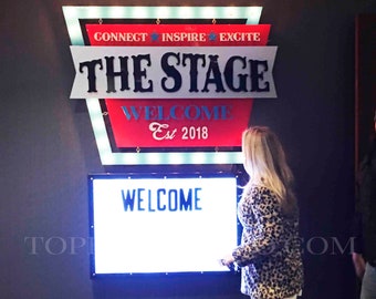 Könnte beinhalten: Ein rot-weiß-blaues Schild mit dem Text "CONNECT INSPIRE EXCITE THE STAGE WELCOME Est 2018" und ein digitales Schild mit dem Text "WELCOME" in einem dunklen Raum.