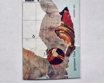 May include: A rectangular collage card featuring a grid calendar section labeled SUNDAY with the number 6. Overlaid are torn paper layers in shades of brown, cream, and dark red with circular patterns. The text ocean air and gossamer blue is printed.