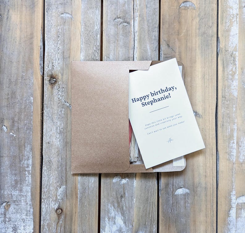 May include: A kraft paper envelope with a white card inside. The card says "Happy birthday, Stephanie!" and has a message about bringing joy and clarity.