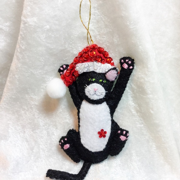 Black & white cat with christmas hat ornament.