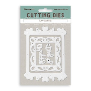 May include: A Stamperia brand cutting die set titled Happy Day Frames, featuring white metal dies for creating ornate rectangular frames. The packaging is light blue and beige with the text Cutting Dies and Happy Day Frames clearly visible.