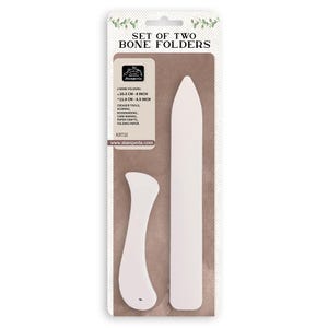 May include: A package containing two white bone folders. The package reads "SET OF TWO BONE FOLDERS". The folders are creaser tools for scoring, bookbinding, card making, paper crafts, and folding paper. One folder is 8 inches long, the other is 4.5 inches.