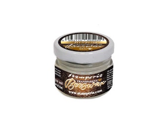 May include: A small glass jar of Stamperia Transparent Beeswax, a clear wax for crafting and sealing projects. The jar is labeled with the brand name and product information, including the size, 20 ml.