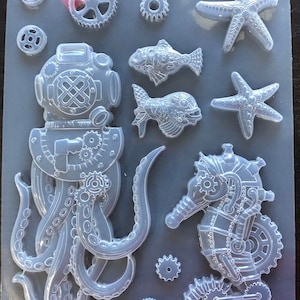 May include: A clear silicone mould with a variety of sea creature designs, including an octopus, a seahorse, two fish, and two starfish. The designs are all detailed with gears and other steampunk elements.