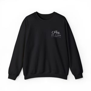 Op de afbeelding: Zwart sweatshirt met de tekst "Mrs. EST. 11-2024" in wit.