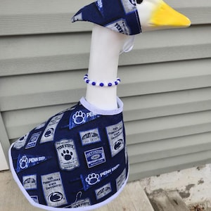 May include: A decorative goose figurine wearing a navy blue and white outfit with Penn State University logos. The goose has a matching hat and a beaded necklace. The outfit includes a vest with the text "PENN STATE" and other university-related graphics.