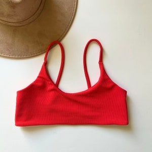 May include: Red ribbed bikini top with adjustable straps.