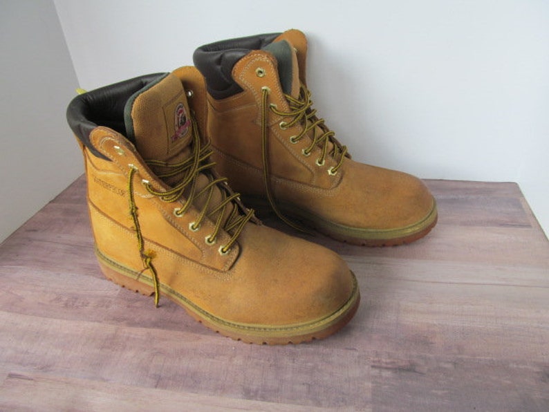 Op de afbeelding: Een paar bruine werkschoenen met zwarte veters en een bovenwerk van bruin leer. De schoenen hebben een Goodyear-randconstructie en een stalen neus.