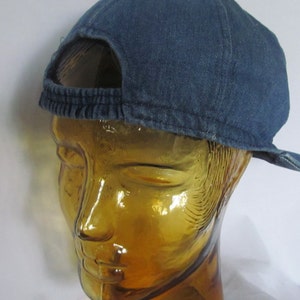 May include: A blue denim baseball cap with a mesh back panel. The cap has a curved brim and a strap with a buckle.