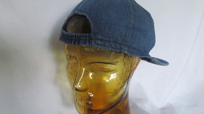 May include: A blue denim baseball cap with a mesh back panel. The cap has a curved brim and a strap with a buckle.