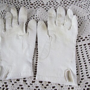 Puede incluir: Un par de guantes de cuero blanco con un dise&ntilde;o sencillo. Los guantes est&aacute;n hechos de cuero suave y flexible y tienen un acabado liso.