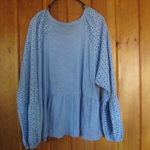 Pu&ograve; includere: Una blusa azzurra a maniche lunghe con vita arricciata e dettagli a occhiello sulle maniche.
