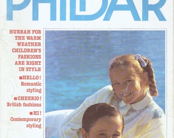 Könnte beinhalten: Ein Magazincover mit zwei Kindern, die Strickpullover tragen. Das Magazin heißt "PHILDAR" und enthält den Text "HURRAH FOR THE WARM WEATHER CHILDREN'S FASHIONS ARE RIGHT IN STYLE" und "HELLO! Romantic styling CHEERIO! British fashions HI! Contemporary styling Featuring different blends of yarns on a white background WELCOME! Tropical fashions".