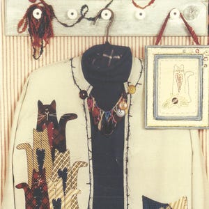 May include: A pattern for a sweatshirt jacket with a patchwork pocket and appliquéd cats. The pattern includes instructions for an embroidered cat picture. The pattern is called "Caught Up in Stitches" and the pattern number is KS-221.