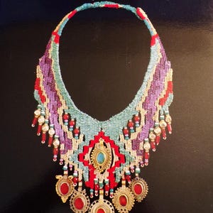 May include: A book cover featuring a colorful beaded necklace with a turquoise stone and the title "Beads and Threads: A New Technique for Fiber Jewelry" by Diane Fitzgerald and Helen Banes.